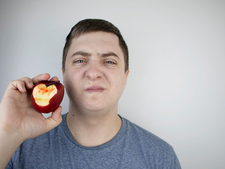 A man bit an apple and blood came out of his gums. Gum bleeding, symptoms of gingivitis,...