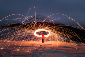 Fire show with lot of sparks in night winter mountains. Landscape photography