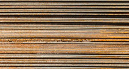 Racks of metal profiles. Metal is stored in an open warehouse. Wet and rusty on the street. Old grunge background made of rusty iron for shooting flatleys on the table
