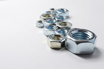 New chrome screw-nut of different sizes on a white background. Concept.