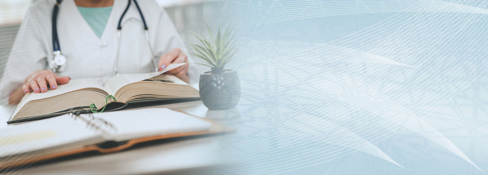 Female doctor reading a textbook; panoramic banner