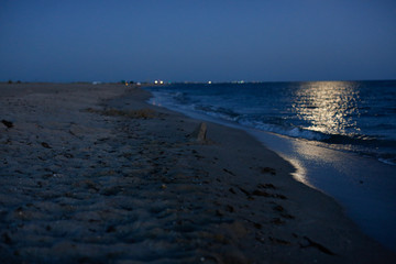 Moon over the sea at night, dark blue sky
