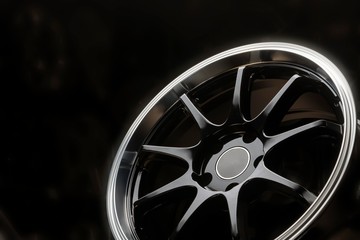 black new alloy wheels with a polished rim on a dark background close up