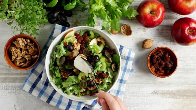 Waldorf Salad. Decorating the dish. Application with a spoon of salad dressing.