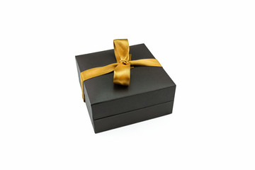 Closed brown jewelry box wrapped with gold ribbon in a bow, isolated on a white background with a clipping path.
