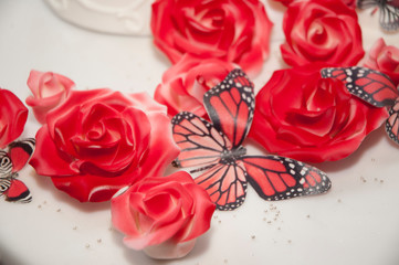 Wedding cake with cream and decorations of roses and butterflies