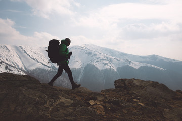 Amazing landscape with snowy mountains range and hiker with backpack on a foreground