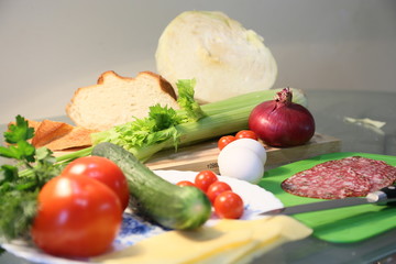 Still life from fresh vegetables and bread: celery, tomatoes, greens, cabbages