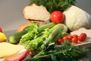 Still life from fresh vegetables and bread: celery, tomatoes, greens, cabbages