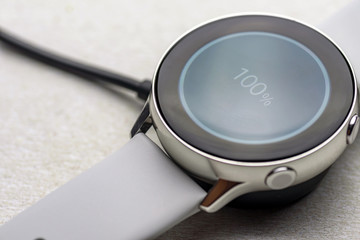 smart watch wireless charging on charging pad on kitchen worktop table