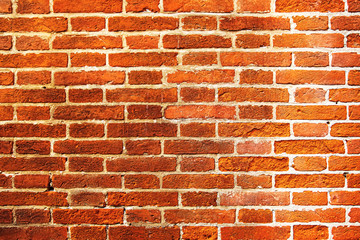 Weathered texture of a rough red-brown brick wall