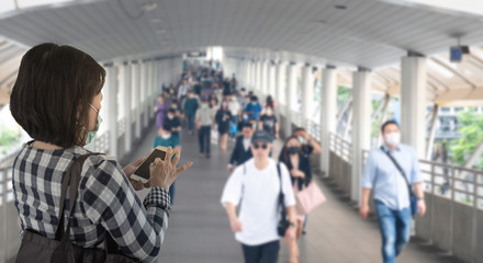 Defocused crowd wearing medical masks for virus protection and walking in walkway, blurred background, coronavirus, china covid-19 virus epidemic, pandemic, outbreak and air pollution concept