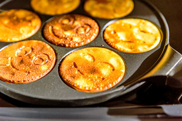 pancake frying pan with smile face pancake cooking on cooker in kitchen