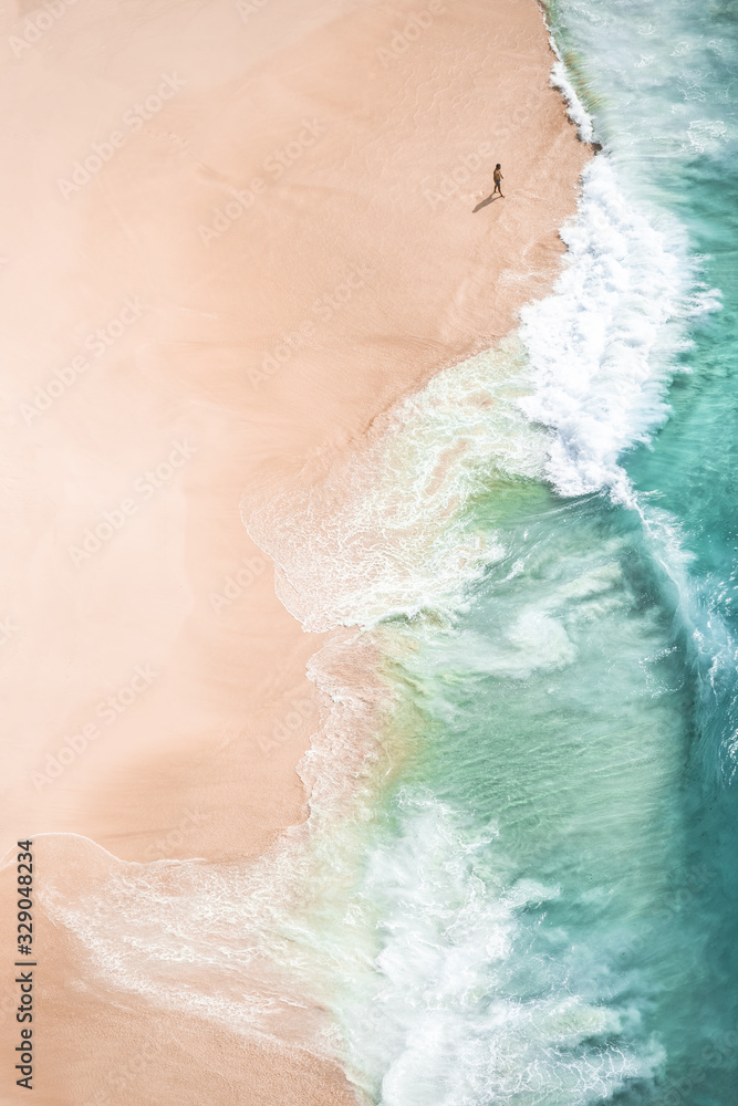 Canvas Prints View from above, stunning aerial view of a person walking on a beautiful beach bathed by a turquoise sea during sunset. Kelingking beach, Nusa Penida, Indonesia. - Canvas Prints
