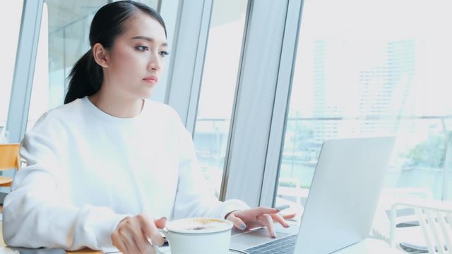 4k uhd entrepreneur  startup business owner attractive asian female business woman communication with smartphone and laptop white dress cheerful and smile with confience blur office background