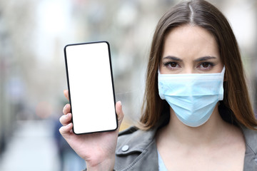 Woman with protective mask showing phone screen