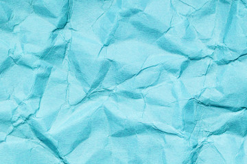 Blue crumpled paper texture. Wrinkled surface background. Creased vibrant color backdrop for graphic design.