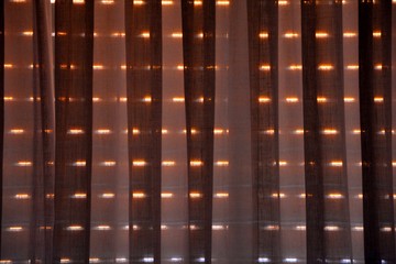 one blind and a curtain in a dark room