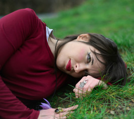 Dreaming girl lying on the grass in a concept of happiness, self confidence and peace of mind