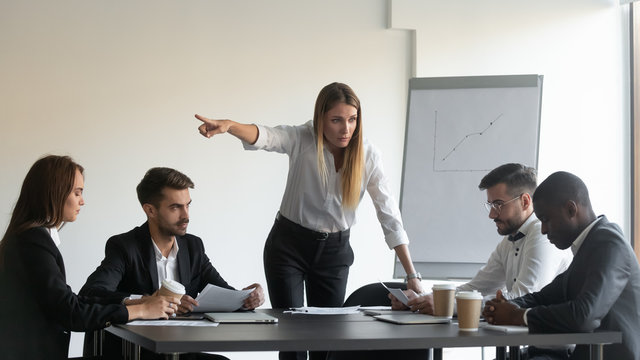 Angry female team leader director manager asking upset frustrated african american employee to leave business group meeting because of project failure, professional incompetence, bad work results.