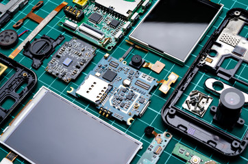 Boards and components of disassembled old mobile phones with semiconductor elements close-up