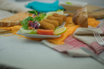 croquettes in white bowl on the table with more food