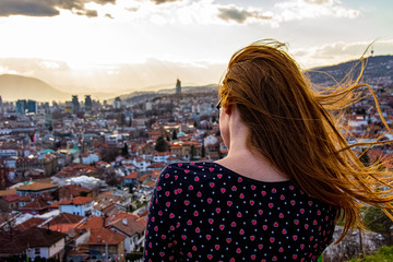 Girl looking to the city of Sarajevo from Yellow bastion shooted from behind