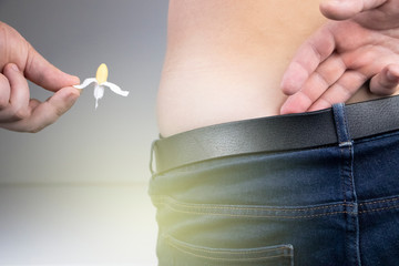 A man at a proctologist's appointment. The doctor holds a rectal suppository before entering the...