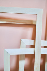 Naklejka na ściany i meble Wooden frames on a pink background. Abstraction. Frames for photos and paintings. Decoration