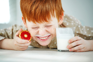 A child drinks milk with cookies.