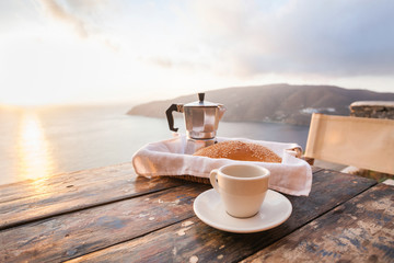 Mediterranean breakfast, cup of coffee and fresh bread on a table with beautiful sea view at the background - obrazy, fototapety, plakaty