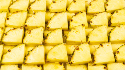 Pineapple juicy yellow slices background. Top view.