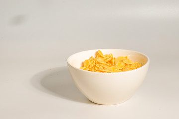 Corn flakes falling to the white bowl. Motion.