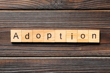 adoption word written on wood block. adoption text on table, concept
