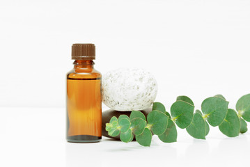 Eucalyptus essential oil in the bottle over white background.