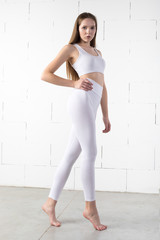 Girl in white blank leggings and a crop top. Mock-up.