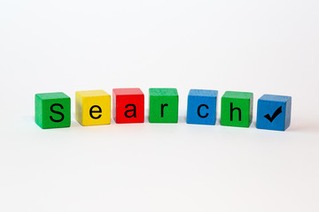 Colorful toy blocks with the word search and a check exempted against a white background with space for text