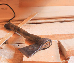 forged axe on the wooden floor. tools at the construction site