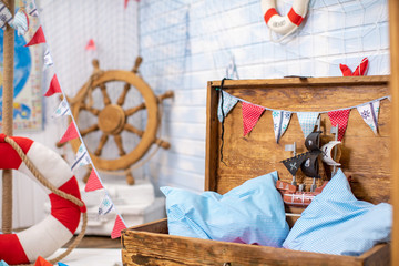 Decoration of the room in a pirate style, with a helm and a treasure chest