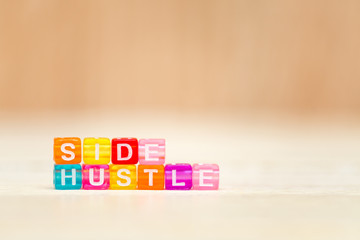 Side hustle phrase made of cube beads of different colors. Concept of additional income.