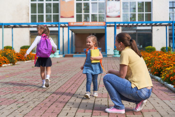 Mom meets daughter from elementary school. child runs into the arms his mother.