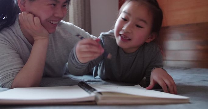 Happy asian little girl talking to her mother at home sharing ideas with painting home education parent kid communication concept 4k slow motion footage