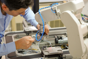Close-up of Service Engineer ( Mechanic ) repairing robot arm in a technology laboratory. Industry...