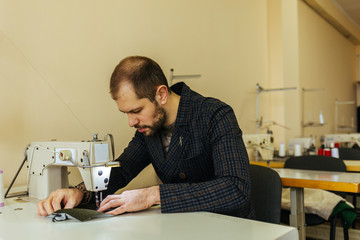 Close up of a male shoemaker working with leather textile at his workshop