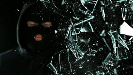 Detail of shattered glass, burglar on background