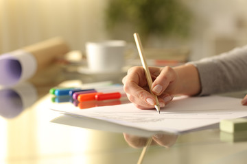 Designer woman drawing sketch with pencil on a desk