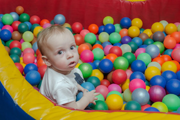 Fototapeta na wymiar baby boy playing with colorful balls