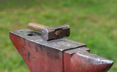 A large hammer of a blacksmith lies on a special table.
