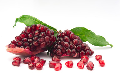 Ripe fresh juicy tropical POMEGRANATE fruit seeds with leaves isolated on white background. Full dept of field. 