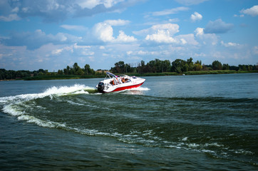 Obraz premium Indoor motor boat on the river. Rest on the river by boat. Fishing on the Volga River. Saratov, Russia, July 15, 2017